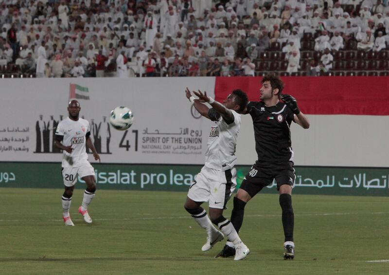 Abu Dhabi, United Arab Emirates - November 23, 2012.  Ismaeel Al Hamadi ( white uniform of Al Ahli ) battles out with Adel Mohamed( goal keeper no 40 of Al Wahda ), at the ongoing Etisalat Pro League.  ( Jeffrey E Biteng / The National )