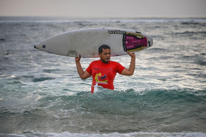 Dery Setyawan, a survivor of the December 26, 2004 tsunami, holdinghis surfboard after surfing on Lhoknga beach in Banda Aceh, Aceh province.  AFP