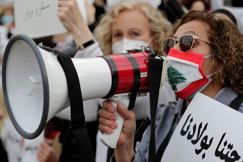 Lebanese women hold placards as they protest against the country's political paralysis and deep economic crisis in Beirut on the occasion of Mother's Day. AFP