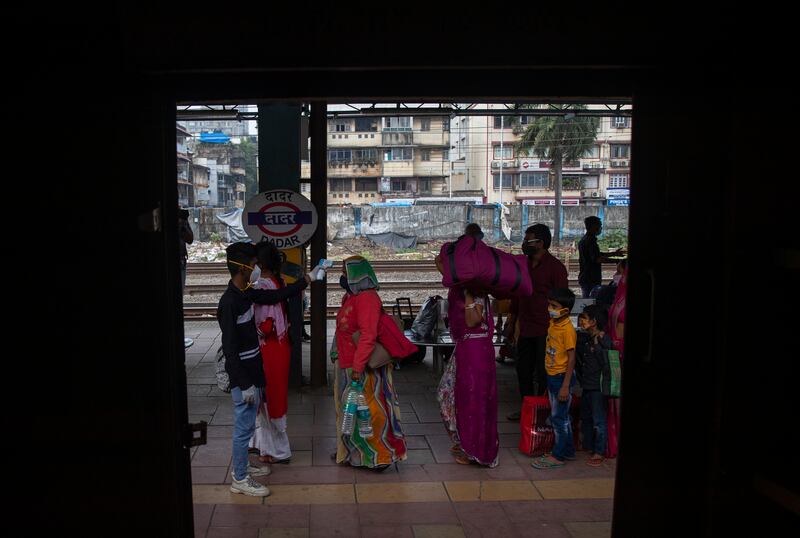 A health worker checks the body temperatures of travellers in Mumbai.  AP Photo