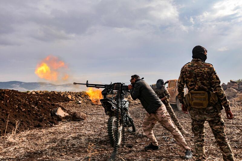 A Syrian fighter fires a machinegun mounted on the back of motorcycle during military drills by the Turkish-backed Suleiman Shah Division in the opposition-held Afrin region of northern Syria. AFP