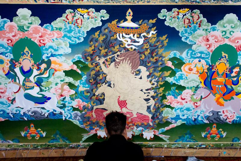 Exile Tibetan artist Tenzin Yeshi, 29, paints a traditional painting called 'thangka' in Dharmsala, India, on June 27, 2018. Ashwini Bhatia / AP Photo