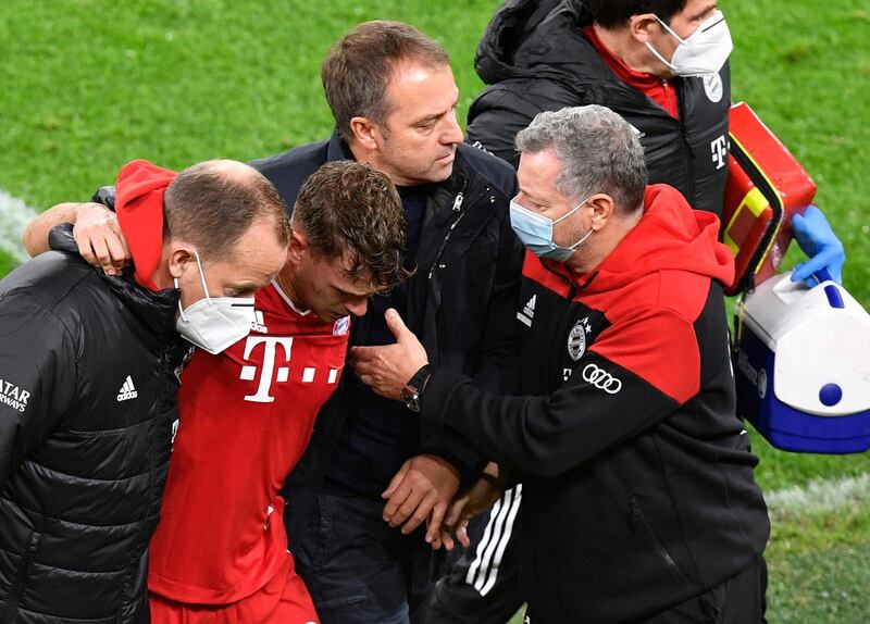 Bayern manager Hansi Flick consoles iinjured Bayern midfielder Joshua Kimmich. EPA