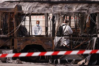 Forensics officers inspect the scene after buses were torched overnight in Aubervilliers, near Paris. EPA 