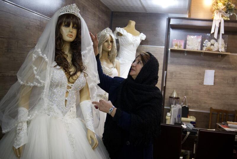 Iranian woman fixing the dress on mannequin in her store in Tehran on Jan 9, 2014.  Maryam Rahmanian for The National