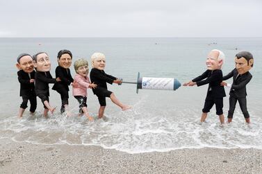 Oxfam activists with 'Big Heads' caricatures of G7 leaders during a protest at a beach near Falmouth, on the sidelines of the summit, in Cornwall, Britain. Reuters