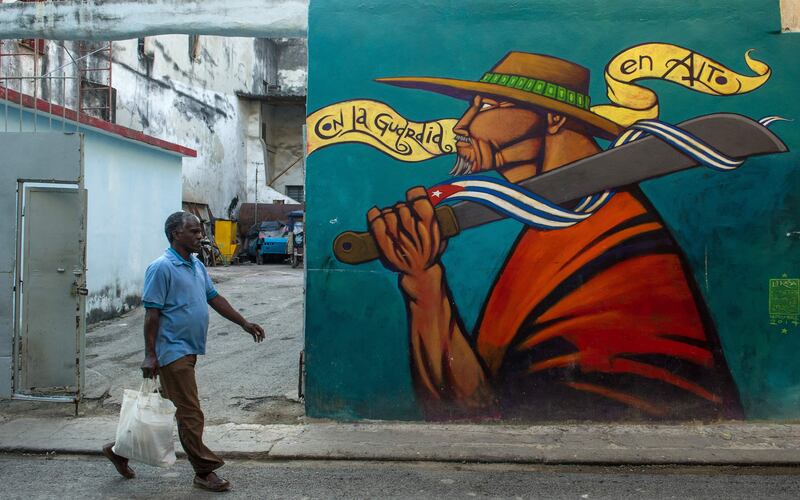 A Cuban walks by a graffiti of street art in Havana, on July 12, 2017. / AFP PHOTO / YAMIL LAGE