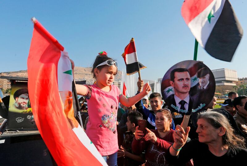 Citizens carry portraits of president Bashar Al Assad as they gather to condemn the strikes carried out by the United States, Britain and France against the Syrian regime. Louai Beshara / AFP Photo
