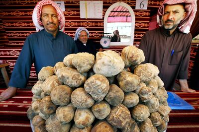Kuwaiti vendors sell truffles at a market in al-Rai, an industrial zone northwest of Kuwait City on March 1, 2018. 
White or beige, but never black, the "desert truffle" is a rare delicacy with a dedicated marketplace in Kuwait, where remnants of the Iraqi invasion and changing weather patterns have decimated local production. / AFP PHOTO / YASSER AL-ZAYYAT