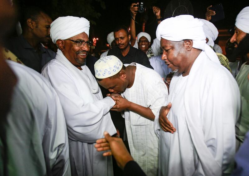 Sudanese President Omar al-Bashir shakes hands with Sufi Muslim clerics at the presidential palace in the capital Khartoum on January 3, 2019.  / AFP / ASHRAF SHAZLY
