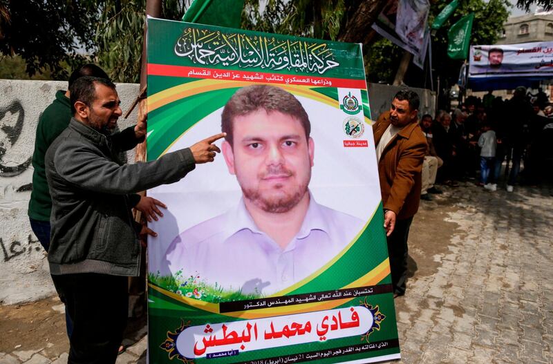 A picture taken on April 21, 2018 shows men holding up a poster portrait of 35-year-old Palestinian professor and Hamas member Fadi Mohammad al-Batsh who was killed early in the day in Malaysia outside his family's house in Jabalia in the northern Gaza strip.
Malaysian police said that the research scientist, who specialised in energy issues, was killed in a drive-by motorcycle shooting as he headed on foot to take part in dawn Muslim prayers on April 21 in Kuala Lumpur.
His family accused Israel's Mossad spy agency of killing him. / AFP PHOTO / MAHMUD HAMS