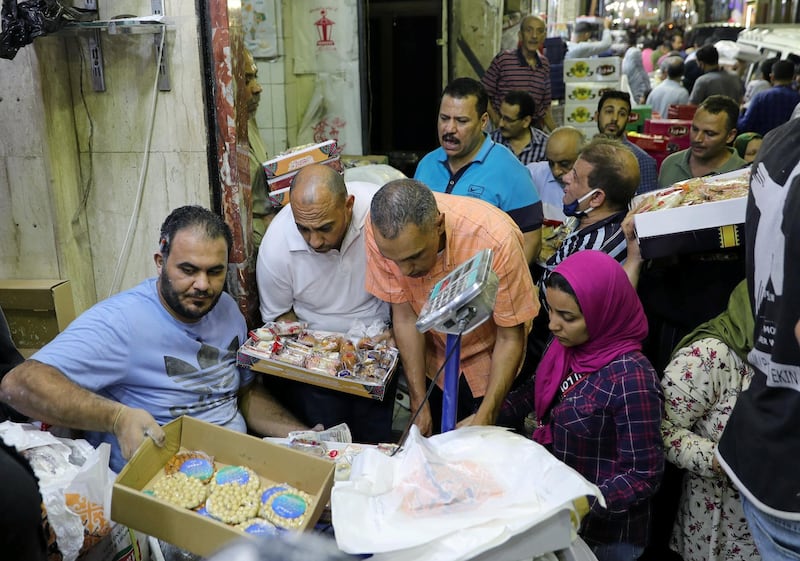 Customers buy handmade sweets at a street market ahead of Mawlid al-Nabi, the birthday of Prophet Mohammad, in Cairo, Egypt October 28, 2020, Picture taken October 28, 2020. Egypt REUTERS/Mohamed Abd El Ghany