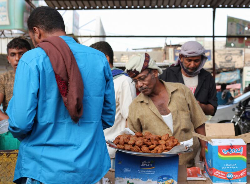A street food vendor talks to customers at a market in Lahj, Yemen.