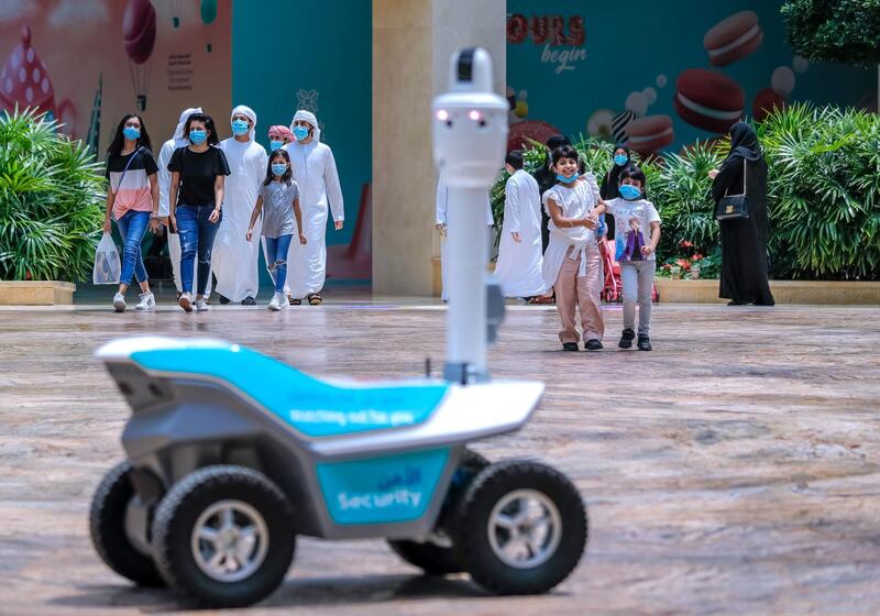 Abu Dhabi, United Arab Emirates, August 19, 2020.  
   Children are amazed at a roving robot on wheels which does thermal checks around the Yas Mall.
Victor Besa /The National
Section:  NA
Reporter:  Haneen Dajani