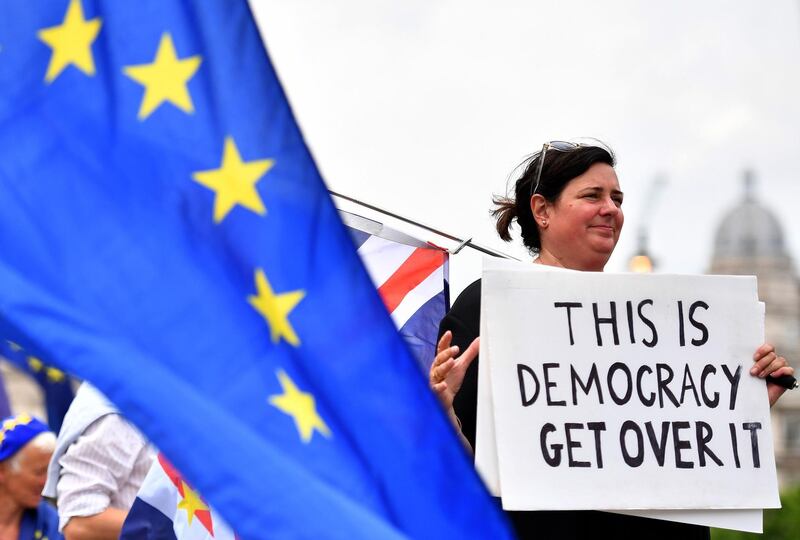 A pro-EU demonstrator holds a placard  during an anti-Brexit protest outside the Houses of Parliament in London on June 13, 2018.  / AFP / Ben STANSALL
