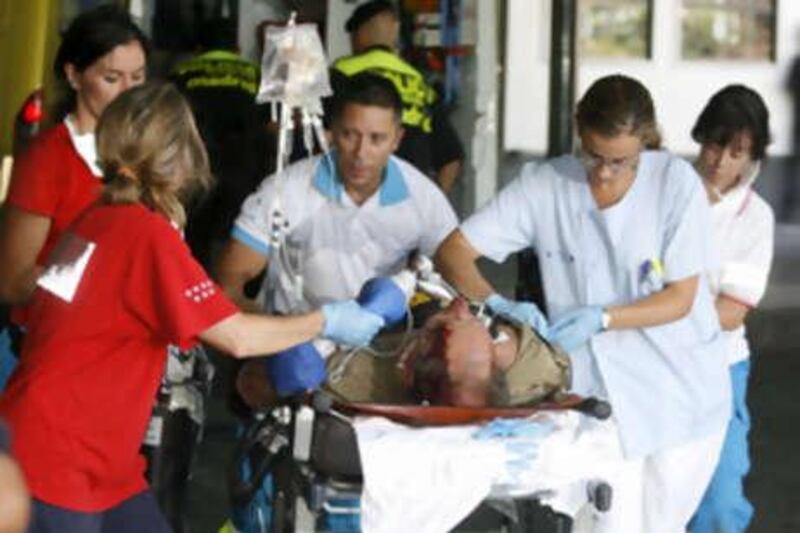 Medical personel tend an injured passenger in Madrid's Barajas airport after a Spanair airliner bound for the Canary Islands swerved off the runway while taking off from the airport, Madrid, Spain, Wednesday, Aug. 20, 2008. Local media are reporting that at least 20 people died in the accident and 57 were injured. (AP Photo/EFE, Juan Carlos Hidalgo) ** NO SALES, LATIN AMERICA, CARIBBEAN AND SPAIN OUT **