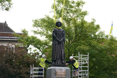 A statue of Baroness Margaret Thatcher is lowered into place in her home town of Grantham, England, Sunday May 15, 2022.  (Joe Giddens / PA via AP)