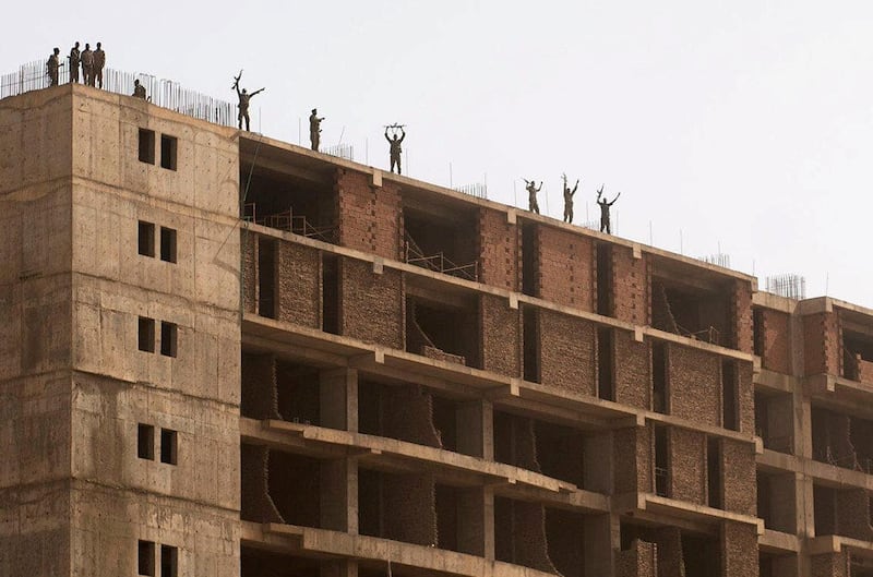 Sudanese soldiers stand on a building as demonstrators attend a protest rally. Reuters