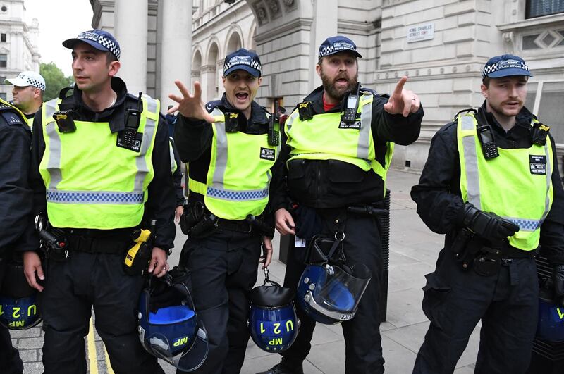 Police officers react as protesters attempt to push past them in Whitehall. AFP