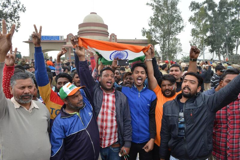 Indian men shout slogans and wave the national flag near the India-Pakistan border in Wagah on March 1, 2019, as they wait for the return of an Indian Air Force pilot being returned by Pakistan. Pakistan was set to free a captured Indian pilot on March 1 in a "peace gesture" aimed at lowering temperatures with its nuclear arch-rival, after rare aerial raids ignited fears of a dangerous conflict in South Asia. AFP