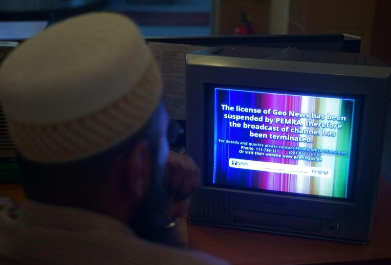 A viewer in Islamabad  looks at a television screen flashing a suspension of service notice on the GEO News channel on June 6, 2014.  B K Bangash / AP Photo