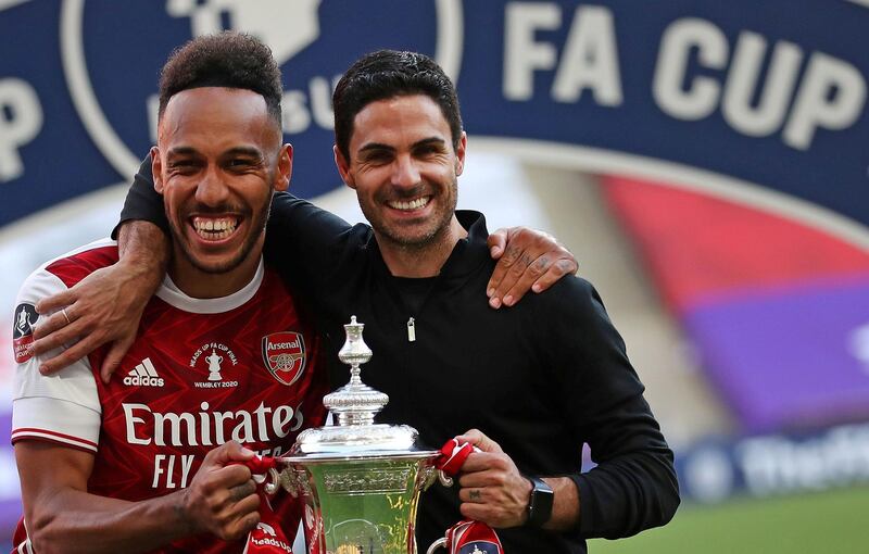 Arsenal's Gabonese striker Pierre-Emerick Aubameyang (L) and coach Mikel Arteta hold the winner's trophy. AFP