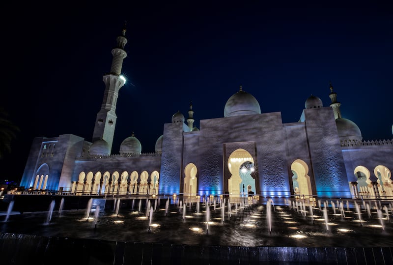 The mosque is lit up at night.