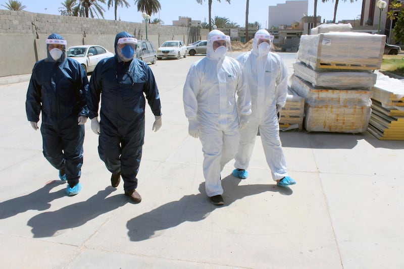 Members of medical team wearing protective suits walk to a clinic in Misrata, Libya. Reuters