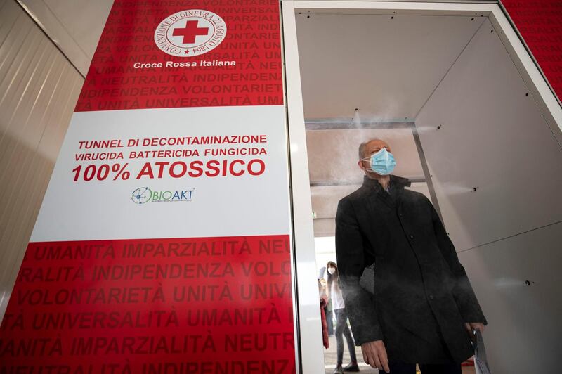 A man is disinfected as he enters an Italian Red Cross vaccination centre set up at Piazza dei Cinquecento, in Rome, Italy. EPA