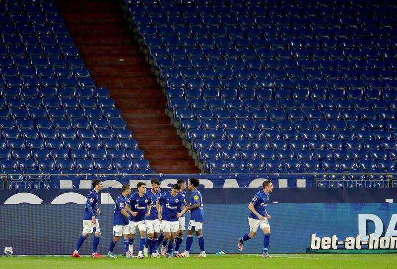 Daniel Caligiuri celebrates with Schalke teammates in front of empty stands on Sunday. EPA