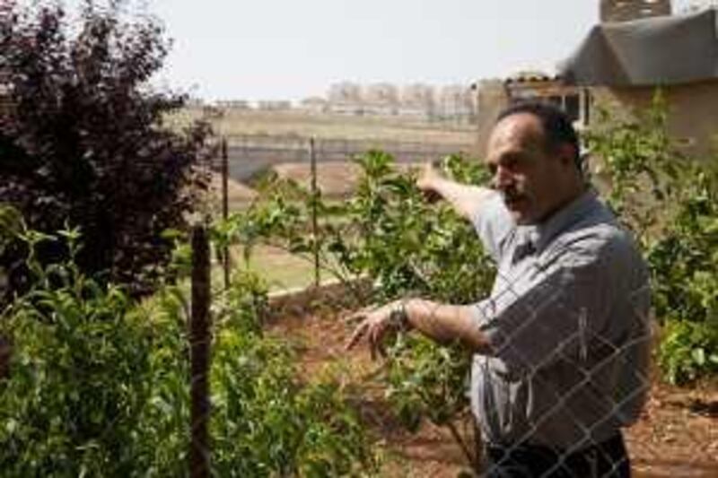 Salah Assaf, 46. In the village of Al Jeeb, West Bank. In the background is the Israeli separation barrier, behing that, the Israeli settlement, Givat Zeev *** Local Caption ***  AlJeeb053.jpg