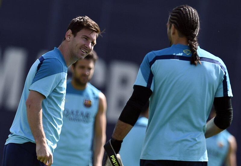 Lionel Messi leans forward to talk with Barcelona keeper Jose Manuel Pinto during the team training session for Saturday's match with Atletico Madrid. Lluis Gene / AFP / May 16, 2014