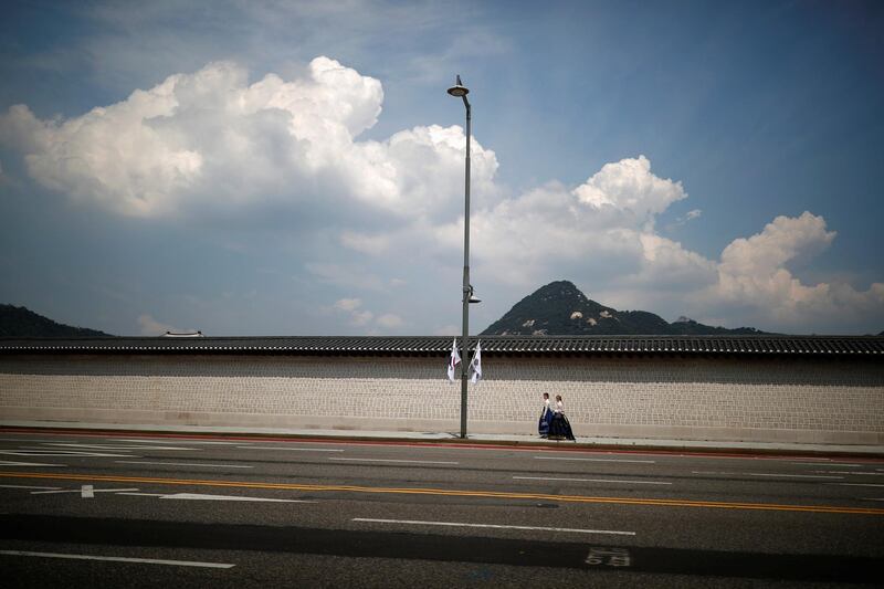 Women in traditional costume Hanbok walk along the wall of Gyeongbok Palace on a hot summer day in Seoul, South Korea. Kim Hong-Ji/Reuters