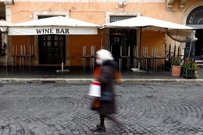 A woman walks past a closed restaurant at Piazza Navona in Rome, Italy. Reuters