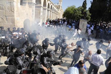 TOPSHOT - Israeli security forces fire sound grenades inside the Al-Aqsa Mosque compound in the Old City of Jerusalem on August 11, 2019, as clashes broke out during the overlapping Jewish and Muslim holidays of Eid al-Adha and the Tisha B'av holdiay inside the hisotric compound which is considered the third-holiest site in Islam and the most sacred for Jews, who revere it as the location of the two biblical-era temples. The compound, which includes the Al-Aqsa mosque and the Dome of the Rock, is one of the most sensitive sites in the Israeli-Palestinian conflict. / AFP / Ahmad GHARABLI