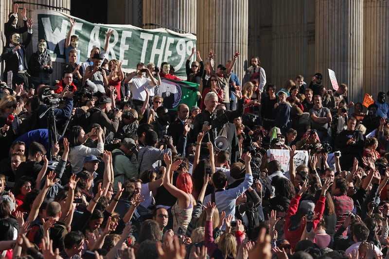 Protesters cheer as Mr Assange, centre, speaks outside St Paul's Cathedral during the 'Occupy London' protest in October 2011. Getty Images