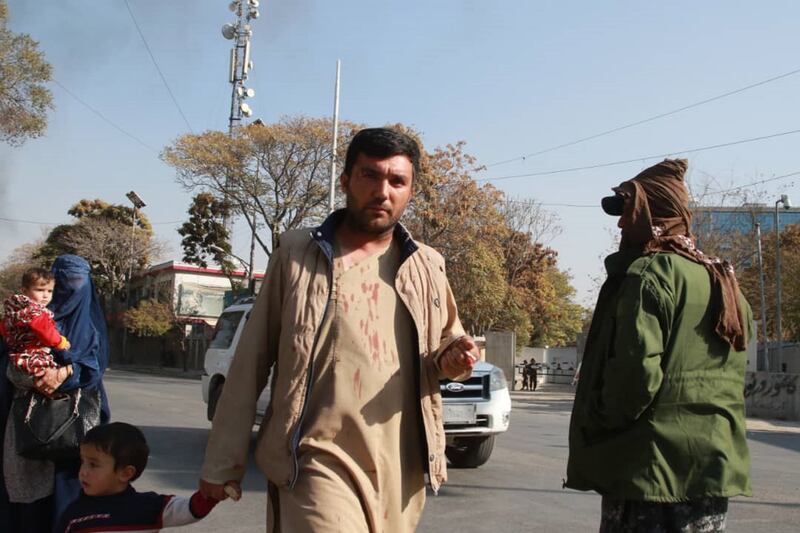 A man with blood stains on his shirt flees the scene of bomb blasts at Afghanistan's biggest military hospital in Kabul. At least 19 people were thought to have been killed, it was reported on Tuesday afternoon. EPA