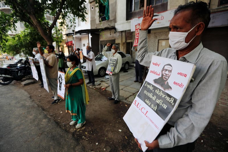 Activists of Socialist Unity Centre of India shout slogans in Ahmedabad, India, Tuesday, June 2, 2020 in solidarity with protests against the recent killing of George Floyd, a black man who died in police custody in Minneapolis, U.S.A., after being restrained by police officers on Memorial Day. Placard in Gujrati reads, "Give justice to George Floyd".(AP Photo/Ajit Solanki)