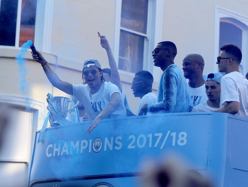 Manchester City's Leroy Sane (L) holds a flare during a bus parade to celebrate their English Premier League title win, in Manchester. Nigel Roddis / EPA