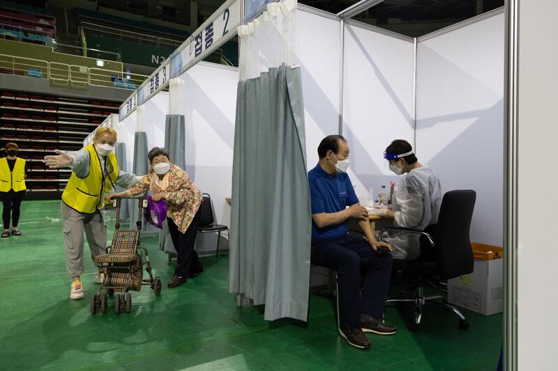 A nurse, right, prepares to administer a dose of the Pfizer-BioNTech Covid-19 vaccine inside the Incheon Samsan World Gymnasium in the Bupyeong district of Incheon, South Korea. Bloomberg