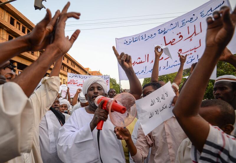 Supporters of Sudanese Islamist movements shout slogans as they rally in front of the Presidential Palace in downtown Khartoum on May 18, 2019.  With talks suspended between protest leaders and Sudan's military over a transfer of power to civilian rule, Islamist movements are backing the army in the hope it will keep sharia law in place. / AFP / MOHAMED EL-SHAHED                   
