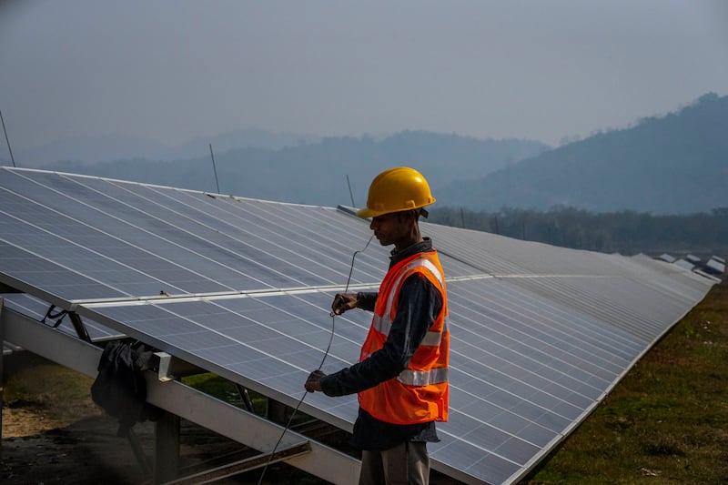 A man works at a solar power plant in Mikir Bamuni village, in Assam, India. The country is one of the world’s largest renewable energy markets. AP