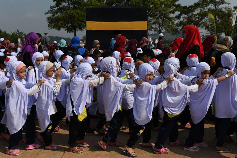 Muslim girls circumambulate a mockup of the Kaaba during an educational simulation of the Hajj pilgrimage in Kuala Lumpur.  AFP