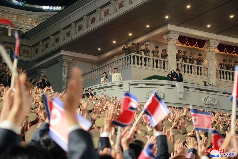 Mr Kim waves from a balcony. AP