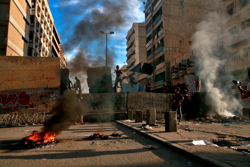 Demonstrators set fires during anti-government protests near Tahrir square, Baghdad, Iraq. AP Photo