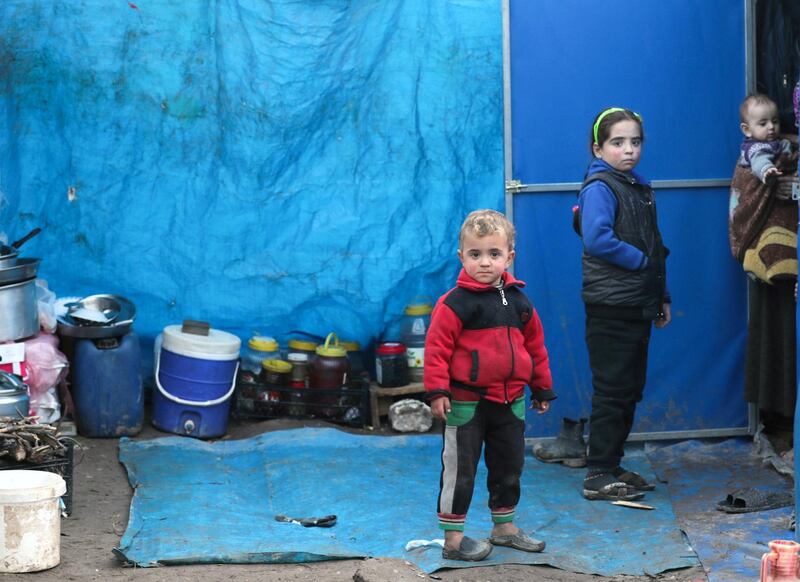 FILE PHOTO: Displaced Syrian children, who fled from southern Idlib, stand outside a tent in Afrin, Syria February 6, 2020. Picture taken February 6, 2020. REUTERS/Khalil Ashawi/File Photo