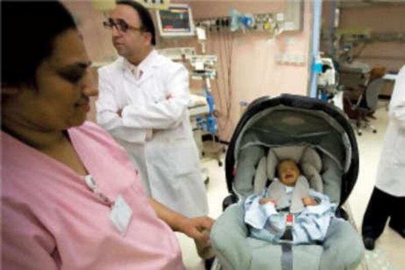 Dr Taisser Atrak, the chairman of Paediatrics at Mafraq Hospital, rear left, started a programme earlier this year to ensure new babies leave hospital in safety seats. The hospital has given away 550 seats to date.