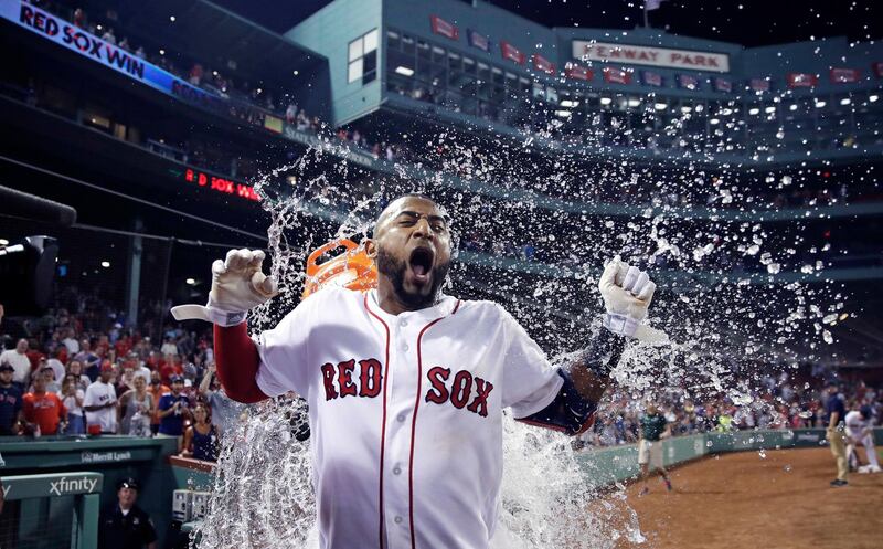 Boston Red Sox's Eduardo Nunez is doused with water in celebration during the bottom of the ninth inning of a baseball game against the Miami Marlins at Fenway Park in Boston. Charles Krupa/AP Photo