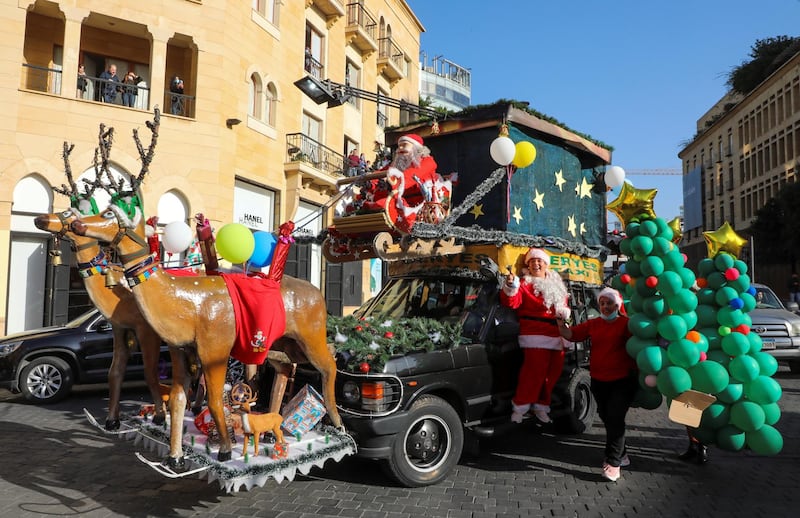 A woman dressed as Santa Claus stands on a decorated vehicle, during a parade ahead of Christmas in downtown Beirut, Lebanon. REUTERS