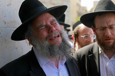Ultra-Orthodox Jewish men react during a funeral ceremony in Jerusalem for Eliezer Goldberg who died in a stampede overnight during a religious gathering in northern Israel, on April 30, 2021. A massive stampede at a densely packed Jewish pilgrimage site killed at least 44 people in Israel, blackening the country's largest COVID-era gathering. / AFP / Menahem KAHANA